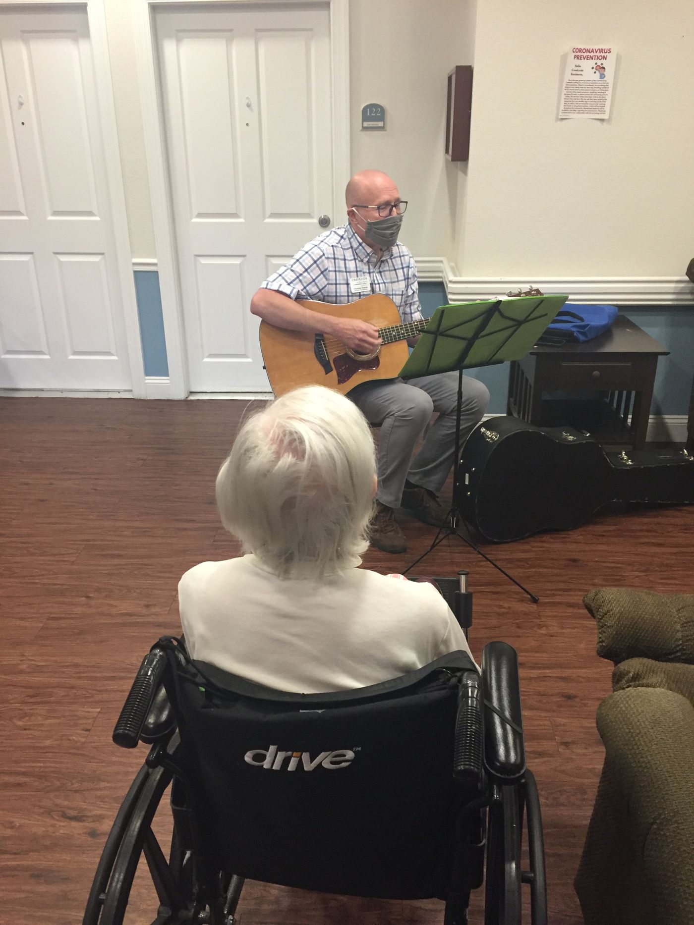 Chris playing guitar for a resident during the early days of Covid